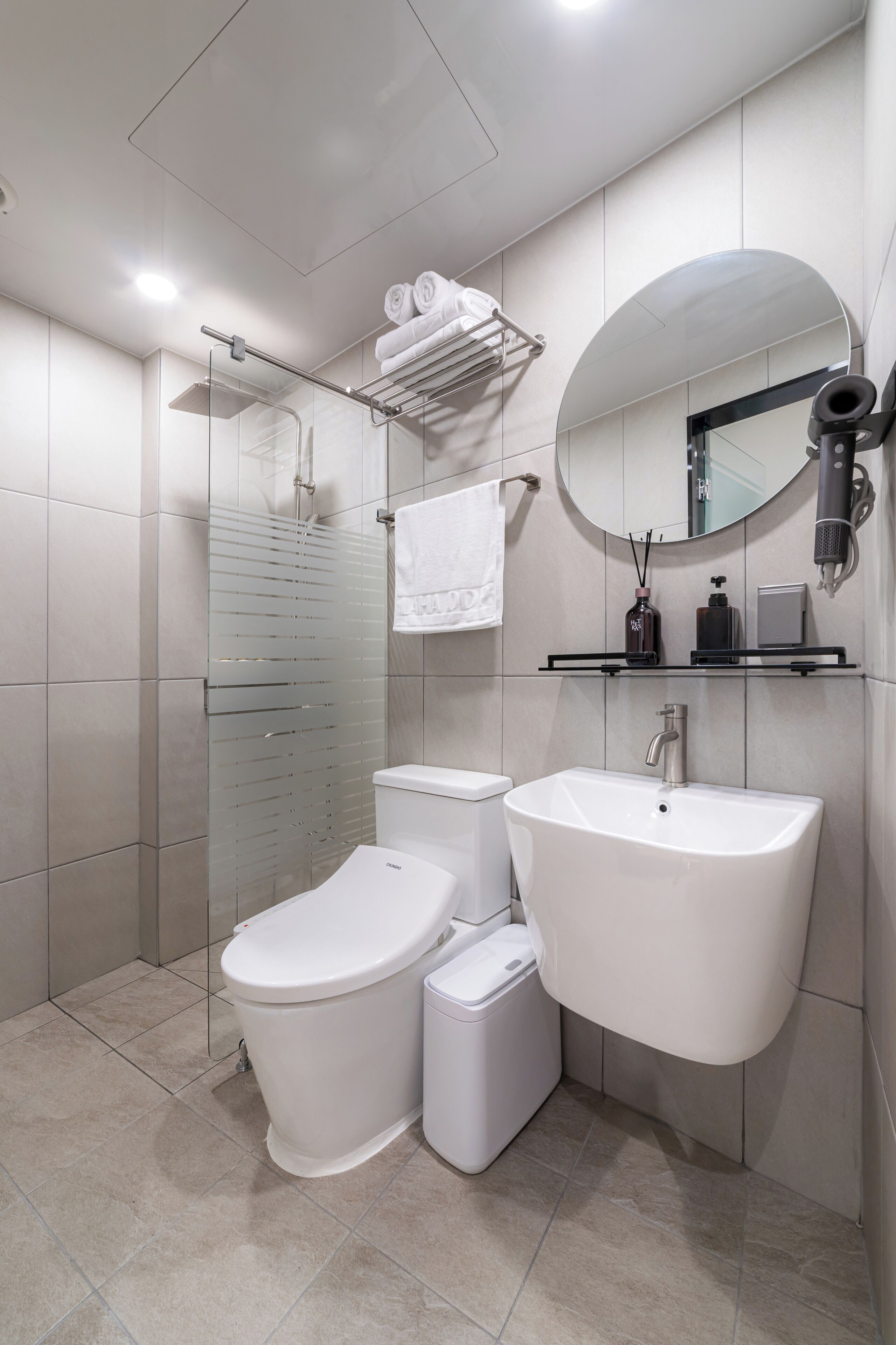 Une salle de bain moderne avec une douche à parois de verre, des toilettes, un bidet, un lavabo et un miroir.