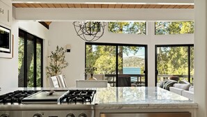 A modern kitchen with a Viking stove, large windows, and a view of the outdoors.