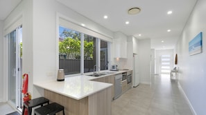 A modern kitchen with a large island, a built-in oven, and a dishwasher.