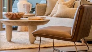 A modern living room with a sofa, a coffee table, a lamp, and a vase. - Byron Social on Jonson (Byron)
