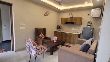 A modern living room with a sofa, a coffee table, and a TV.