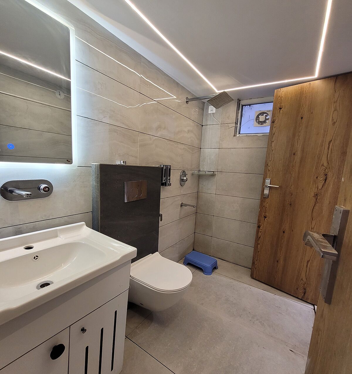 A modern bathroom with a sink, toilet, and shower area.