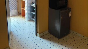 Une cuisine compacte équipée d’un four à micro-ondes, d’un réfrigérateur et d’un évier.