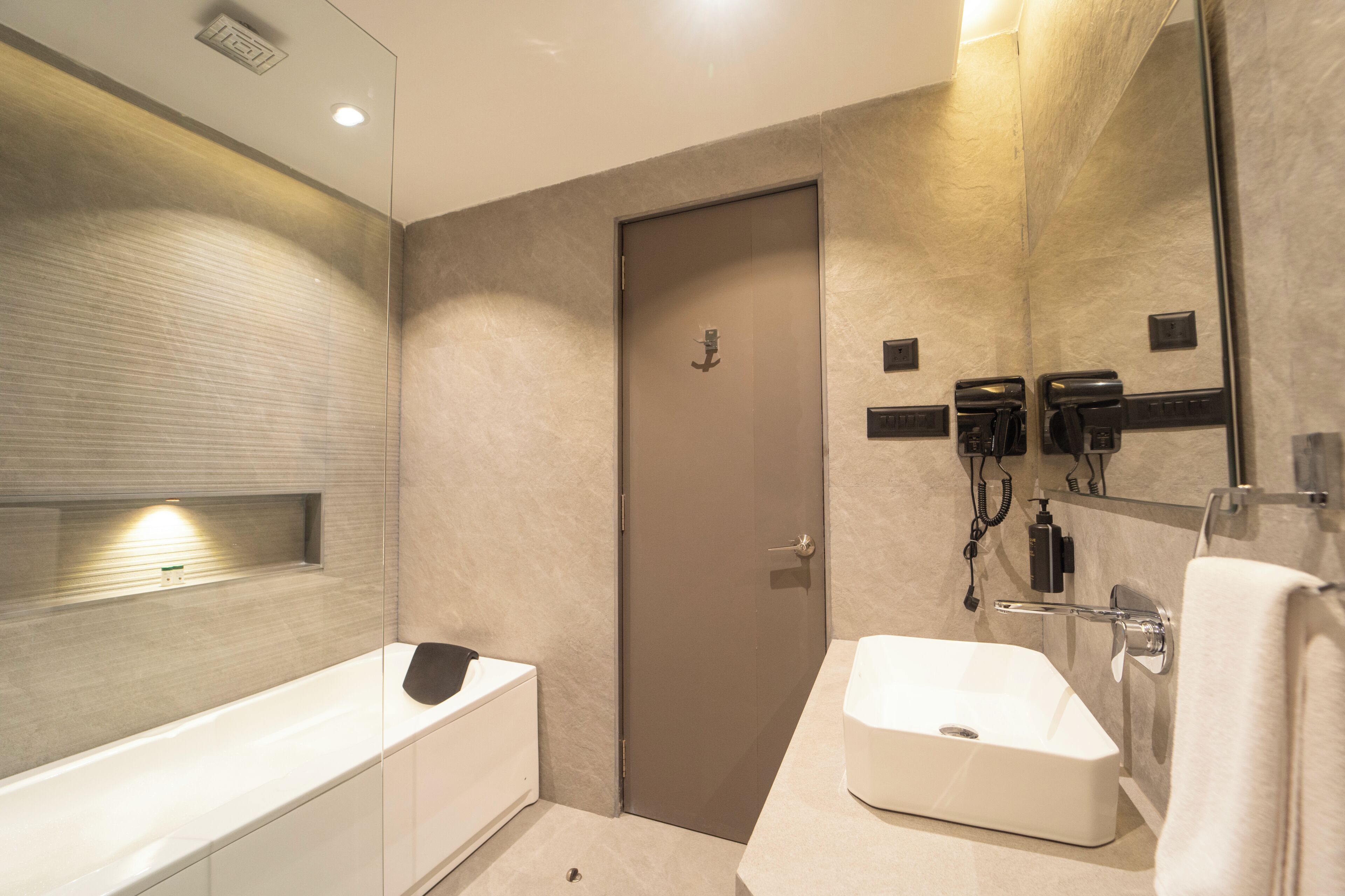A modern bathroom with a bathtub, a sink, a towel rack, and a mirror.