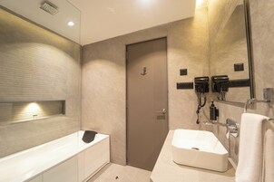 A modern bathroom with a bathtub, a sink, a towel rack, and a mirror.