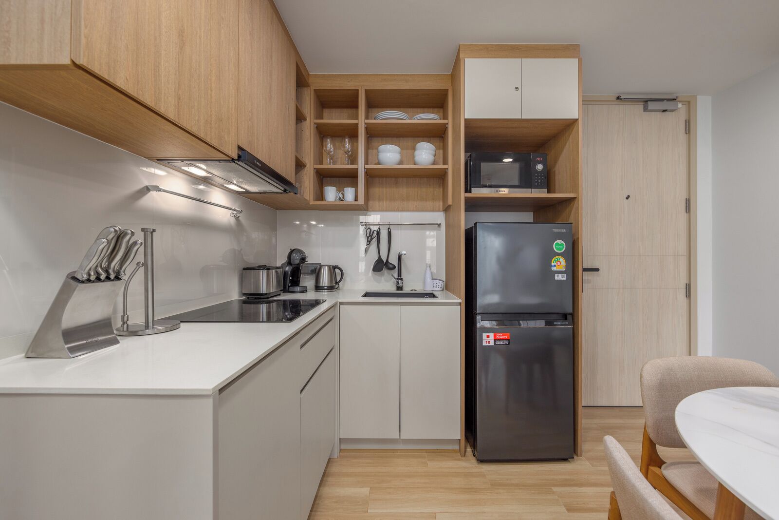 A compact kitchen with a refrigerator, stove, and microwave.