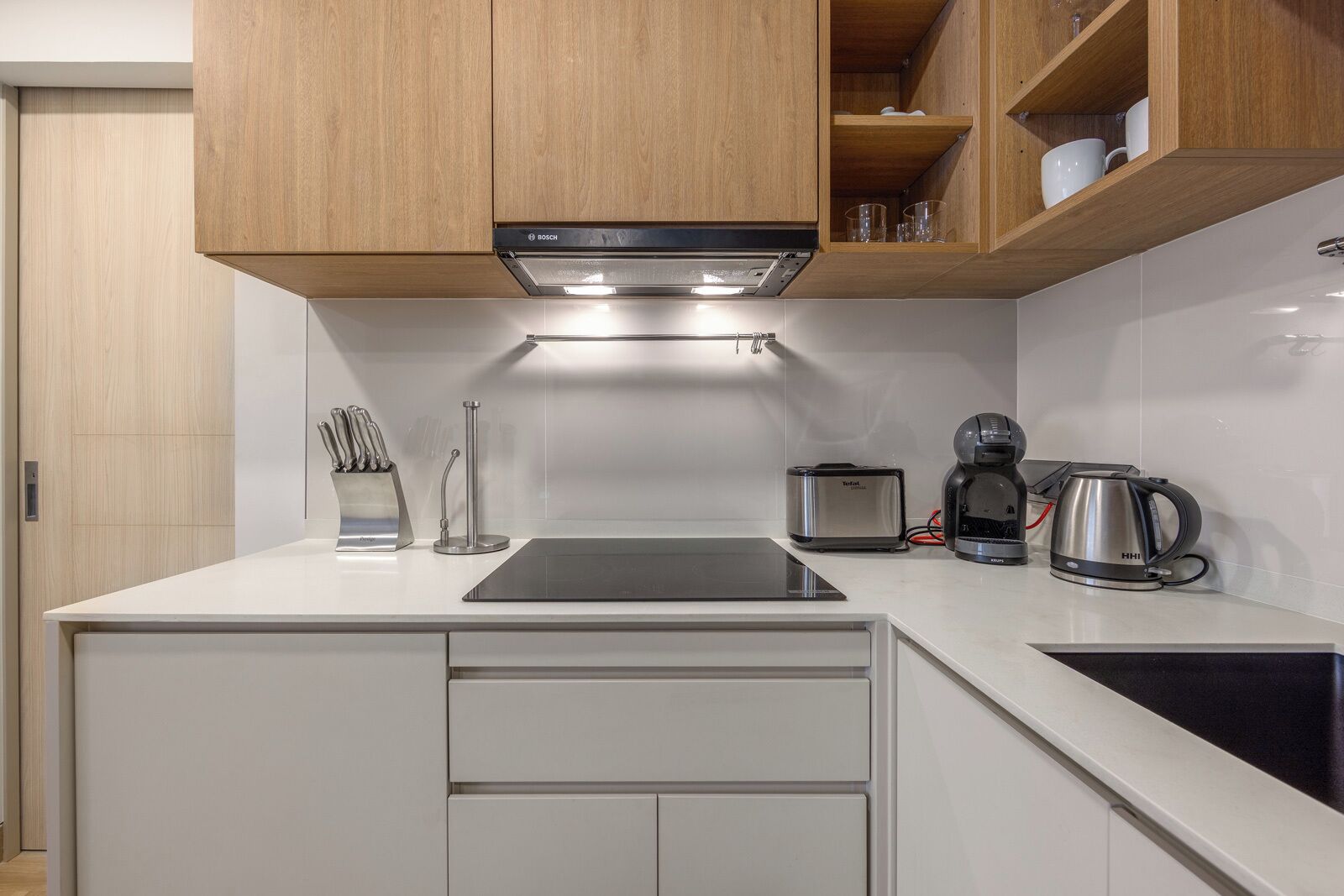 Une cuisine moderne équipée d’une hotte de cuisine Bosch, d’un grille-pain, d’une machine à café et d’un bloc à couteaux.