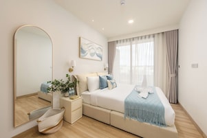 Un dormitorio moderno con una cama grande, mesitas de noche, un espejo y un cuadro en la pared.