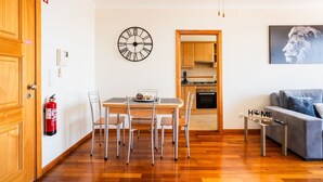 Un espacio habitable compacto con comedor, kitchenette y sofá.