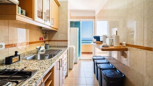 Una cocina moderna con encimeras de granito, electrodomésticos de acero inoxidable y vistas al exterior.