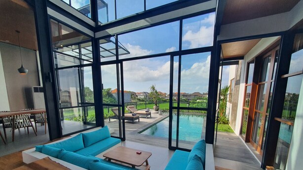 Ein modernes Interieur mit einer großen Glaswand, einem Pool und einer Sitzgelegenheit.