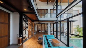 Ein modernes Interieur mit Holzboden, einem großen Fenster und einem Pool im Freien.