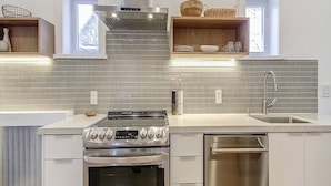 A modern kitchen with a stainless steel stove, a dishwasher, and a tiled backsplash.