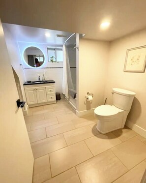Une salle de bain avec des toilettes, un lavabo et un miroir.