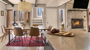 Een moderne keuken met een groot eiland, een open haard en een eethoek met uitzicht op de omgeving.