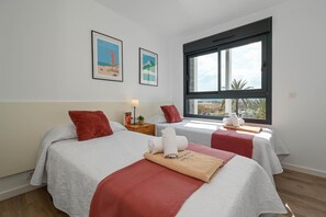 Una habitación de hotel con dos camas, un ventanal grande y obras de arte en la pared.
