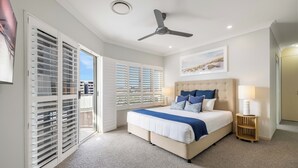 A bedroom with a bed, ceiling fan, and a view through the window. - Admiralty Cove (Sunshine Coast)