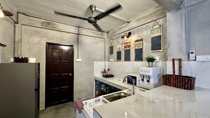 Une cuisine équipée d’un réfrigérateur, d’un four à micro-ondes, d’un évier et d’un ventilateur de plafond.
