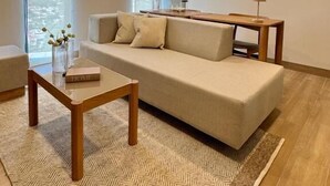 A modern living room with a sofa, coffee table, and a view of the city. - Torre Margot (Guadalajara)