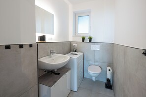 Een haardroger, handdoeken, zeep, toiletpapier