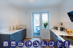 Eine moderne Küche mit einem großen Fenster, einer Spüle, einem Herd und einer Kaffeemaschine.