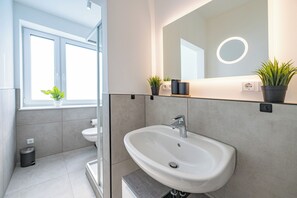 Een haardroger, handdoeken, zeep, toiletpapier