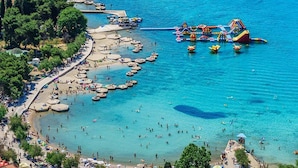 A coastal area with a beach, boats, and a water park. - Studio in Vodice Near Male Vrulje Beach (Vodice)