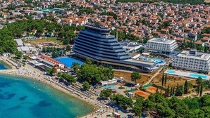 An aerial view of a coastal area with a large hotel, a beach, and a marina. - Studio in Vodice Near Male Vrulje Beach (Vodice)