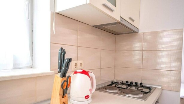 A kitchen with a gas stove, a kettle, and a knife block. - Studio in Vodice Near Male Vrulje Beach (Vodice)