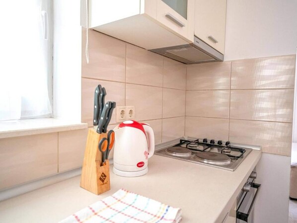 Eine Küche mit Gaskochfeld, Wasserkocher und einem Messerblock.