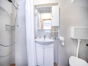 A bathroom with a shower, sink, toilet, and a mirror above the sink. - Studio in Vodice Near Male Vrulje Beach (Vodice)