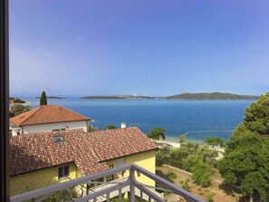 A coastal view with a clear sky, a body of water, and buildings with red-tiled roofs. - Apartment in Brodarica by Sandy Beach (Sibenik)