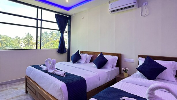 Une chambre d’hôtel avec deux lits, une grande fenêtre, un appareil de climatisation et un plafond doté d’un éclairage bleu.