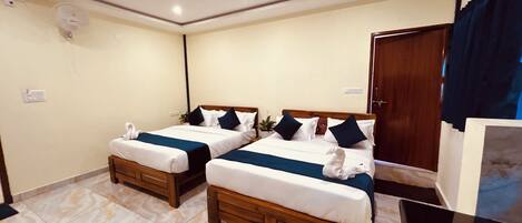 A hotel room with two beds, a TV, a wardrobe, and an air conditioning unit.