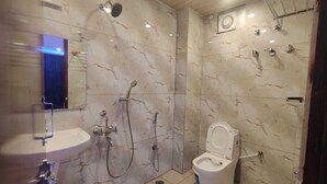 Une salle de bain avec un lavabo, des toilettes et une douche.