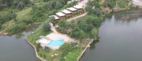 Una isla con piscina, algunos edificios y una extensa masa de agua.