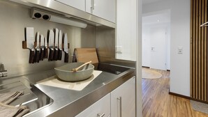 Eine moderne Küche mit Edelstahlgeräten, einem Messerblock und einem Holztisch.
