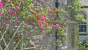 A stone building with a wooden structure in front, possibly a garden or patio area. - 2 bedroom accommodation in Kirby Stephen (Kirby Stephen)