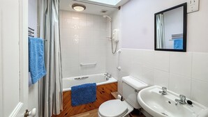 Un baño con ducha, inodoro y lavamanos.