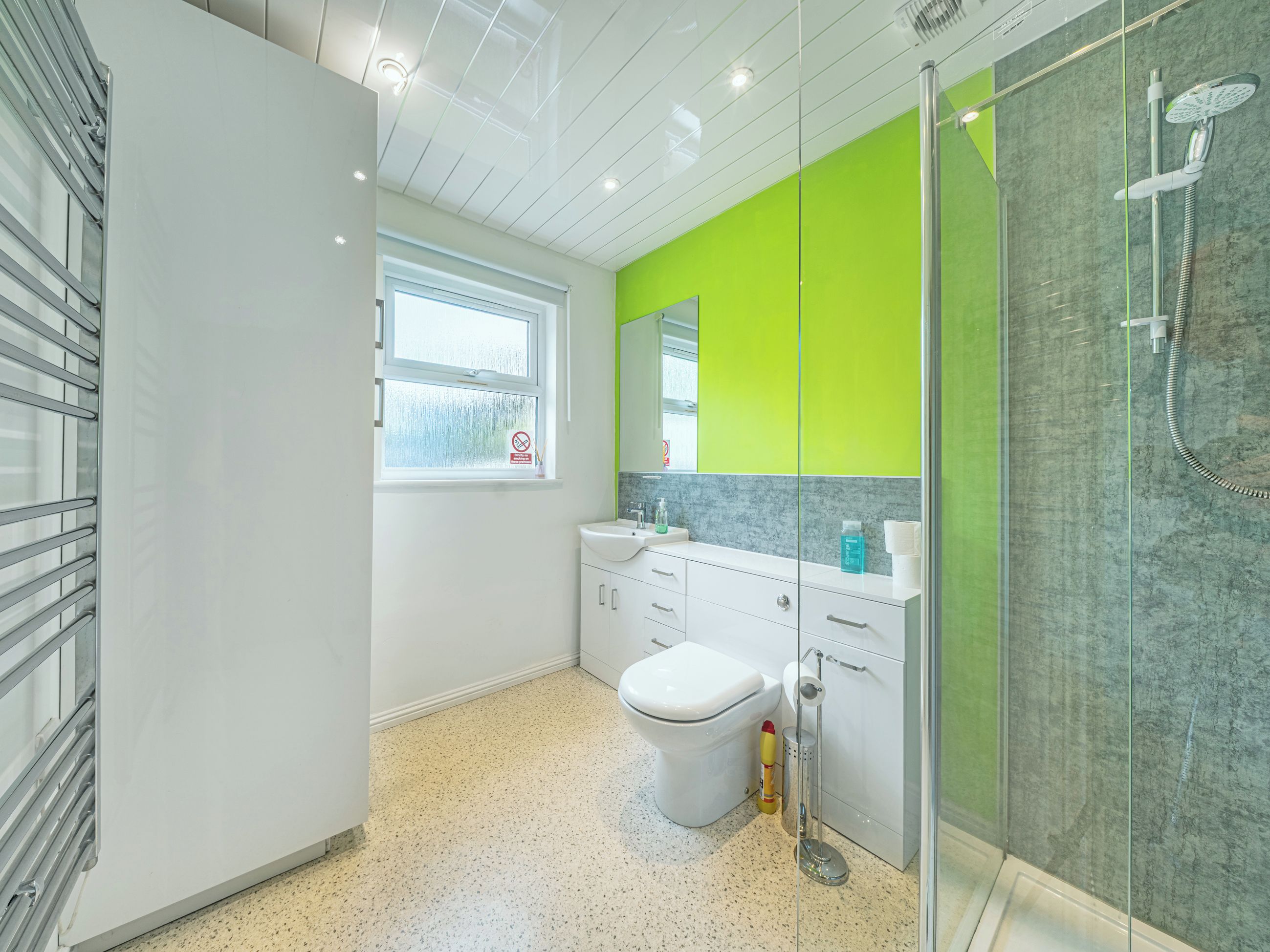 A modern bathroom with a toilet, sink, and shower.