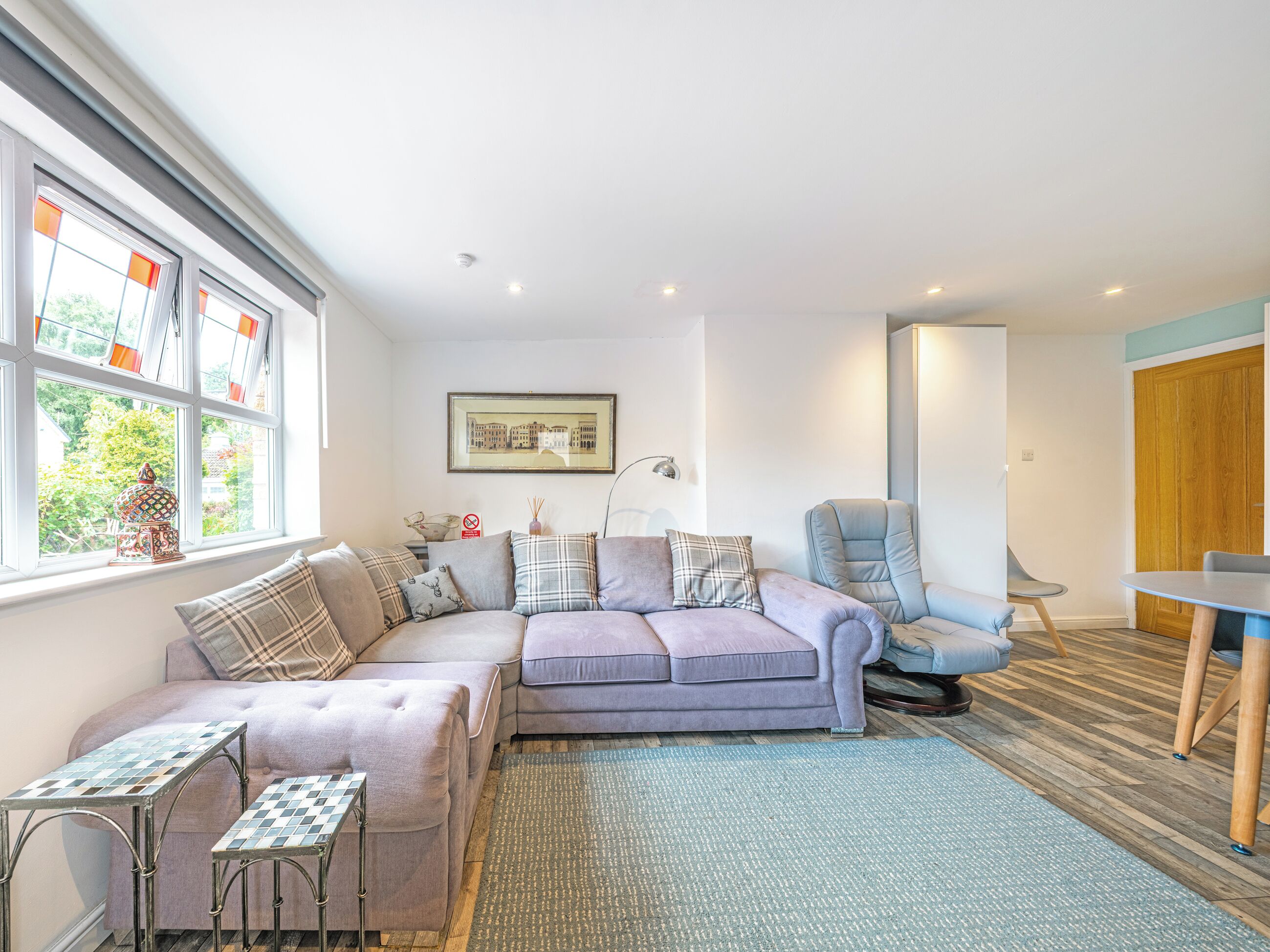 A modern living room with a sectional sofa, a small table, and a chair.
