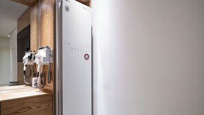 Una cucina moderna con frigorifero integrato, piano di lavoro in legno e macchina da caffè a parete.