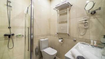Un baño con ducha, inodoro, toallero y lavabo.
