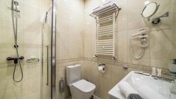 Un baño con ducha, inodoro, toallero y lavabo.