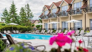 Un hôtel doté d’une piscine, de chaises longues et de parasols.
