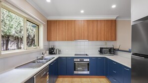Una cocina moderna con horno empotrado, microondas y refrigerador de acero inoxidable.