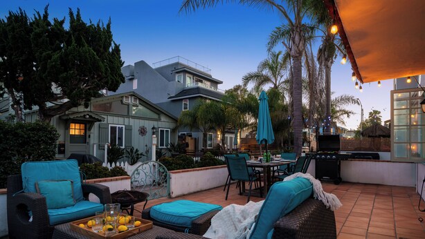 Eine Terrasse mit Gartenmöbeln, einem Grill und einem Essbereich.