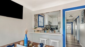 Eine moderne Küche mit weißen Schränken, einer Mikrowelle und einem großen Fenster.