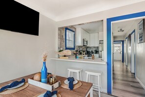 A modern kitchen with white cabinets, a microwave, and a large window. - Steps to Beach | Coastal 3-Units Compound + Patio | Ormond Court Collection (San Diego)