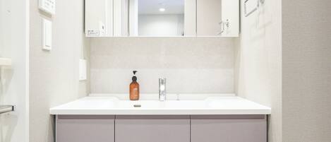 A bathroom with a white sink, a mirror, and a cabinet.